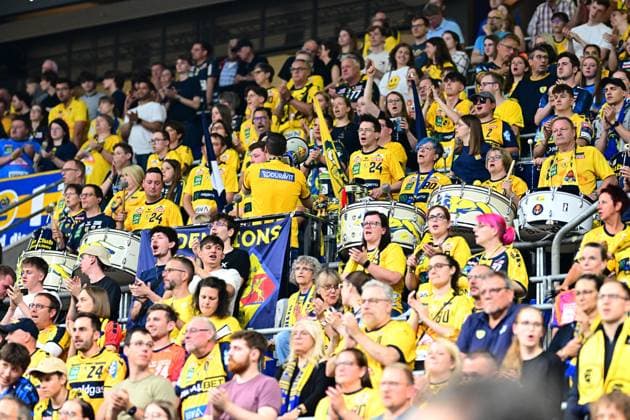 The Rhein Neckar Löwen fan curve is filled with numerous fans in yellow jerseys, who support their team with drums and flags A fan representative in a yellow jersey with Duravit print stands with his back to the camera and directs the atmosphere Rhein Neckar Löwen fans celebrate loudly in the arena Copyright: xMichaelxGelhardtx