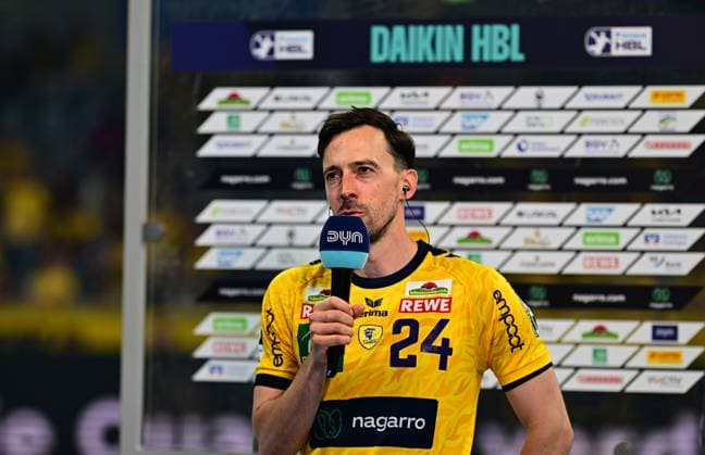 Patrick Groetzki 24 Rhein Neckar Löwen speaks into a microphone with DYN logo in front of a sponsor wall The Daikin HBL banner is visible in the background Patrick Groetzki 24 Rhein Neckar Löwen gives an interview Copyright: xMichaelxGelhardtx