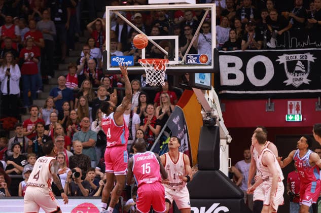 Jeff Garrett Bonn shoots under the basket next to Kur Jongkuch Bonn and Oscar da Silva Bayern , Bonn, Germany, 04 06 2026, Basketball Bundesliga, 3 Semifinals, Telekom Baskets Bonn vs FC Bayern München Basketball