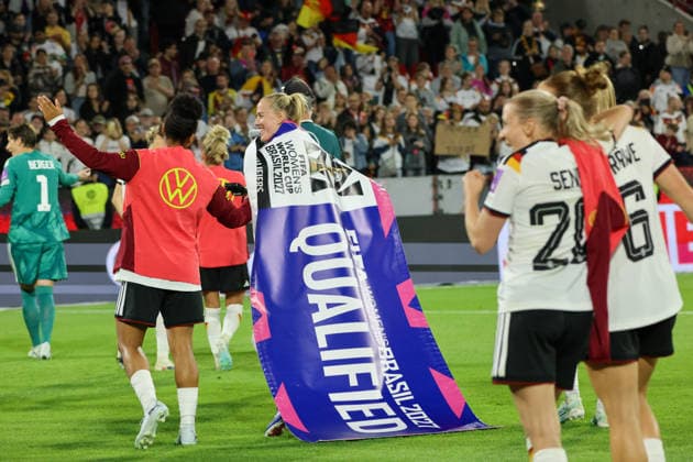 Cologne, Germany 05 06 2026 World Cup qualifying match Germany vs Norway In the picture from left Shekiera Martinez Germany and Lea Schüller Schueller Germany celebrate the secured participation in the 2027 World Cup in Brazil with the official World Cup qualified banner Copyright: HMBxMedia MadeleinexFantini