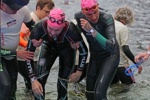 Ironman in Hamburg 2026 Visually impaired Rob Sears l with his guide Ant Munson r leaving the swim course