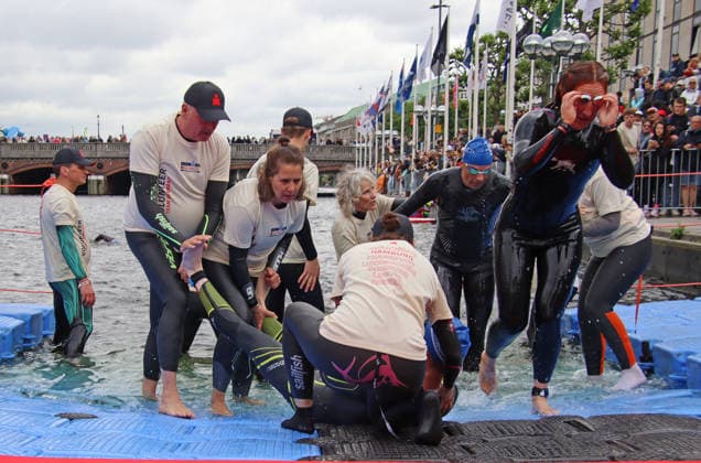 Ironman in Hamburg 2026 Helpers look after an athlete who has developed cramps in his legs after swimming