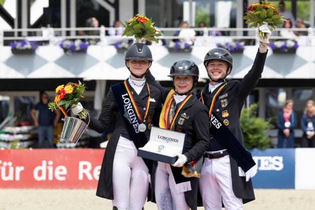 Isabell WERTH GER, mi with Semmieke ROTHENBERGER GER, left , and Raphael NETZ GER, right at the award ceremony, joy, jubilation, laughter, Dressage 03 Longines Grand Optimum Prize, German Championships Grand Prix Kuer 2026, Dressage, Balve Germany, on 07 06 2026 Â