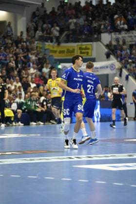 Julian Köster 7 VfL Gummersbach and Kristjan Horžen 27 VfL Gummersbach run together across the pitch at the SCHWALBE arena in Gummersbach Edwin Aspenbäck 78 Rhein Neckar Löwen can be seen in the background Julian Köster 7 VfL Gummersbach and Kristjan Horžen 27 VfL Gummersbach on the pitch Copyright: xspeedshotx xD.xBarndtx