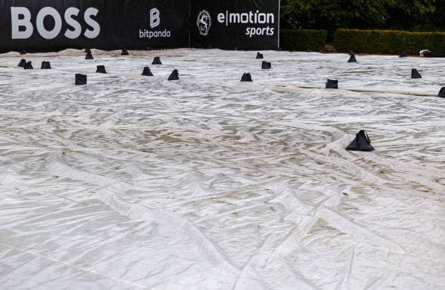 BAU 10.06.2026, Deutschland, Stuttgart, Tennis, BOSS Open 2026, Regen, Regenfeature, Feature, leere Ränge, Rasenabdeckung, Abdeckung, Übersicht, Mensch mit Regenschirm, Schirm *** BAU 10 06 2026, Germany, Stuttgart, tennis, BOSS Open 2026, rain, rain feature, feature, empty courts, grass cover, cover, overview, person with umbrella, umbrella