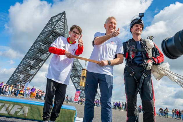 On Thursday 11 6 2026, the FAckellauf of the Special Olympics National Games for the Saarlouis district will start in Ensdorf The skydiver Nils Kammer brought the flame in a miners lamp to the slagheap and handed it over to District Administrator Patrik Lauer and athlete Sascha Wollmer The flame was then passed on bub