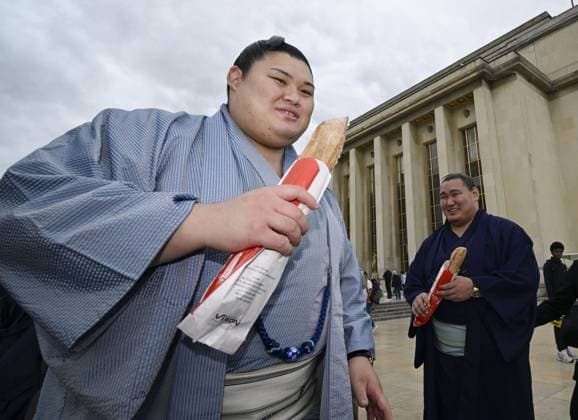 Sumo: Paris tournament Sumo grand champions Onosato (L) and Hoshoryu are pictured with baguettes while sightseeing around Paris landmark Eiffel Tower on June 11, 2026, ahead of a June 13-14 sumo tournament in the French capital.  A14AA0005618478P