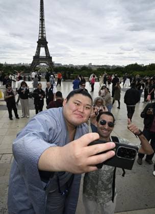 Sumo: Paris tournament Sumo grand champion Onosato takes a selfie with a tourist while sightseeing around Paris landmark Eiffel Tower on June 11, 2026, ahead of a June 13-14 sumo tournament in the French capital.  A14AA0005618479P