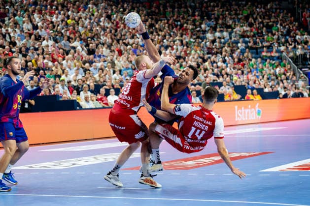 Cologne, 12 05 2026, Handball, Men, EHF Champions League Men 2025 26, Semi-final, Aalborg Handball FC Barcelona Timothey N Guessan FC Barcelona, 19 in duel with Felix Peter Möller Aalborg Handball, 20 and Mads Hoxer Hangaard Aalborg Handball, 14