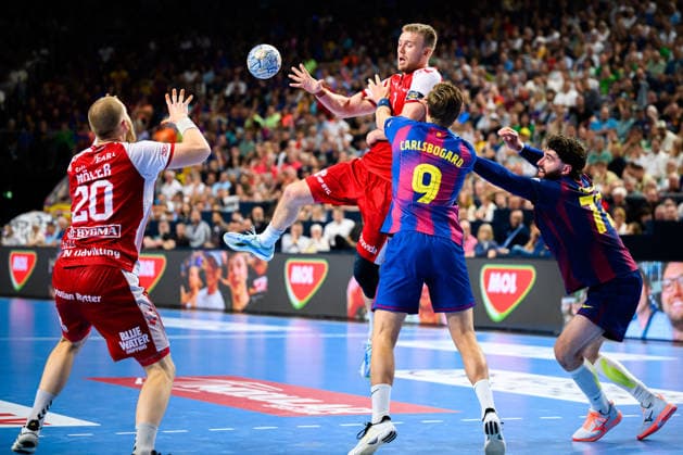 Cologne, Germany Handball EHF CL Final 4 Semi-Final Aalborg Handbold Barca Thomas Arnoldsen Aalborg with the pass to Felix Moeller Aalborg , Jonathan Carlsbogard Barcelona , Ludovic Fabregas Barcelona Cologne Lanxess Arena Nordrhein Westfalen Germany
