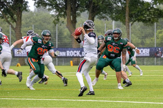 13 06 2026 American Football German Football League 2026 Kiel Baltic Hurricanes Düsseldorf Panther Kiel in green, Düsseldorf in white Isaiah Weed center is attacked by Kielers Tom Kamphausen left and Joshua Köhnlein Kiel Kilia Stadium, Hasseldieksdammer Schleswig Holstein Germany