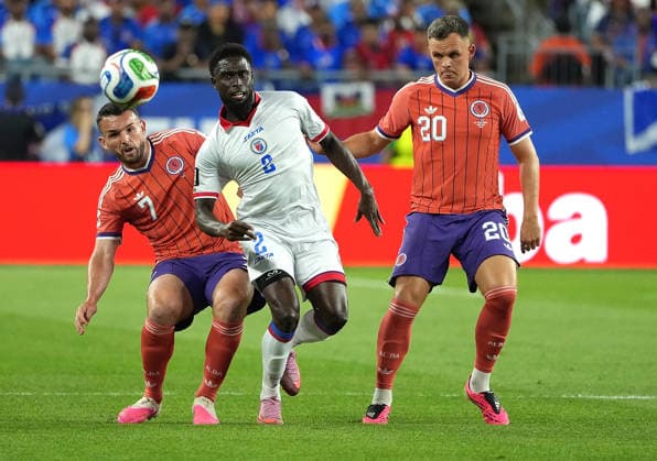 (260614) -- BOSTON, June 14, 2026 -- Lawrence Shankland (R) and John McGinn (L) of Scotland vies with Carlens Arcus of Haiti during the group C match between Haiti and Scotland at the 2026 FIFA World Cup, WM, Weltmeisterschaft, Fussball at Boston Stadium in Boston, the United States, June 13, 2026. ) (SP)U.S.-BOSTON-FOOTBALL-FIFA WORLD CUP-GROUP C-HTI VS SCO HuangxZongzhi 