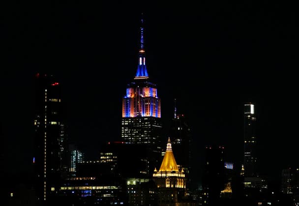 The Empire State Building and other buildings in the Manhattan skyline are lit in the orange and blue colors of the New York Knicks on Saturday, June 13, 2026 in New York City. The New York Knicks won the NBA, Basketball Herren, USA championship defeating the San Antonio Spurs in Game 5 of the NBA Finals to break a 53-year championship drought.  NYP20260613102 JOHNxANGELILLO