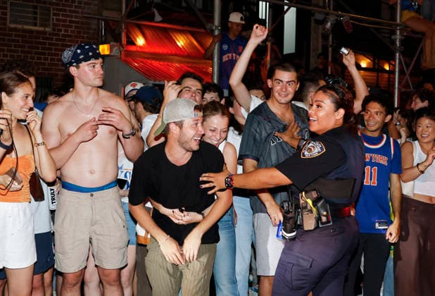 An NYPD police officer contains New York Knicks fans celebrating on the street on St. Marks Place after the Knicks victory in game five of the NBA, Basketball Herren, USA Finals in San Antonio in the early morning hours of Sunday, June 14, 2026 in New York City. The New York Knicks won the NBA championship defeating the San Antonio Spurs in Game 5 of the NBA Finals to break a 53-year championship drought.  NYP20260613115 JOHNxANGELILLO