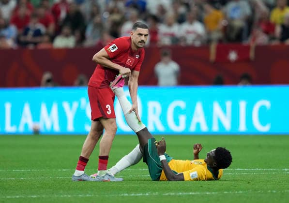 (260614) -- VANCOUVER, June 14, 2026 -- Merih Demiral (L) of T¨¹rkiye helps Mohamed Toure of Australia competes during the group D match between Australia and T¨¹rkiye at the 2026 FIFA World Cup, WM, Weltmeisterschaft, Fussball at BC Place Vancouver in Vancouver, Canada, June 13, 2026. ) (SP)CANADA-VANCOUVER-FOOTBALL-FIFA WORLD CUP-GROUP D-AUS VS TUR MengxYongmin 