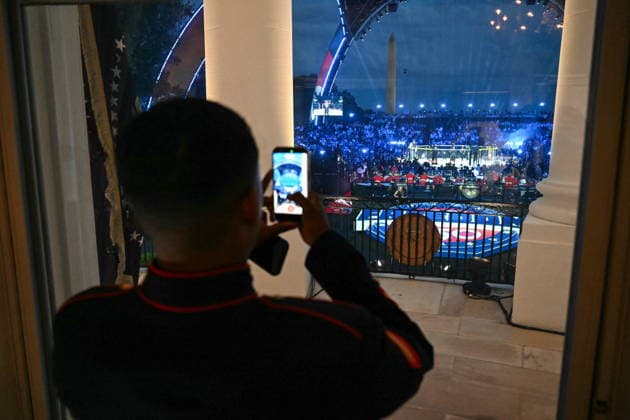 US President Donald Trump hosts UFC Freedom 250 at the White House A US marine takes a photo of the view of the UFC Freedom 250 mixed martial arts event on the South Lawn, as seen from the Blue Room Balcony of the White House in Washington, DC, USA, 14 June 2026. The event is taking place on the 80th birthday of US President Donald Trump. Washington District of Columbia United States  Copyright: xSAULxLOEBx xPOOLx