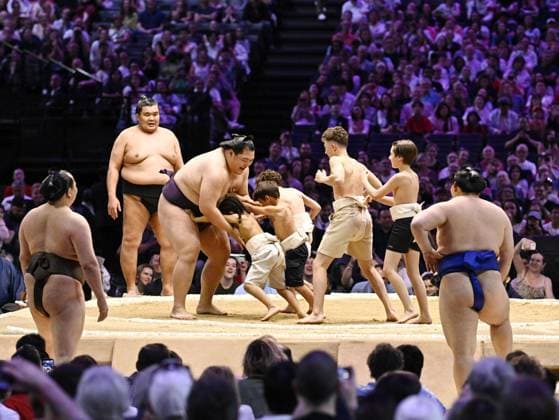 Sumo: Paris tournament Children grapple with maegashira Oho in an exhibition on the second day of a two-day sumo tournament at Accor Arena in Paris on June 14, 2026.  A14AA0005618863P