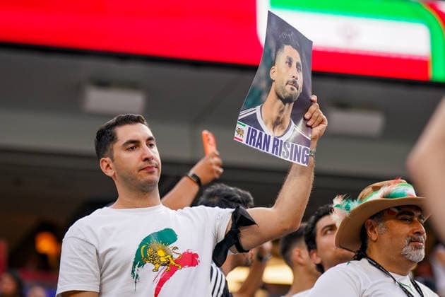 USA: Fußball FIFA World Cup, WM, Weltmeisterschaft, Fussball 2026 Gruppenphase Gruppe G Iran vs Neuseeland SoFi Stadium (Inglewood, Los Angeles County, Kalifornien): Ein iranischer Fan verfolgt das WM-Spiel von den Tribünen aus und hält ein Porträtfoto eines Fußballspielers mit der Aufschrift Iran Rising in die Höhe. Das Motiv verweist auf die Unterstützung der iranischen Opposition, die Protestbewegung und die politische Identität von Exil-Iranern. Die historische Löwen-und-Sonne-Symbolik gilt als Zeichen des Widerstands gegen die Islamische Republik. *** USA Soccer 2026 FIFA World Cup Group Stage Group G Iran vs. New Zealand SoFi Stadium, Inglewood, Los Angeles County, California An Iranian fan watches the World Cup match from the stands and holds aloft a portrait photo of a soccer player with the inscription Iran Rising. The image reflects support for the Iranian opposition, the protest movement, and the political identity of Iranians in exile. The historic lion and sun symbolism is seen as a sign of resistance against the Islamic Republic,detected_source_language Copyright: xJOERANxSTEINSIEKx