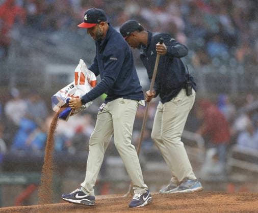 Members of the Atlanta Braves grounds crew work on the mound after heavy rain in the second inning of the game against the San Francisco Giants at Truist Park on Tuesday, June 16, 2026 in Atlanta, Georgia.  ATL20260616109 MikexZarrilli