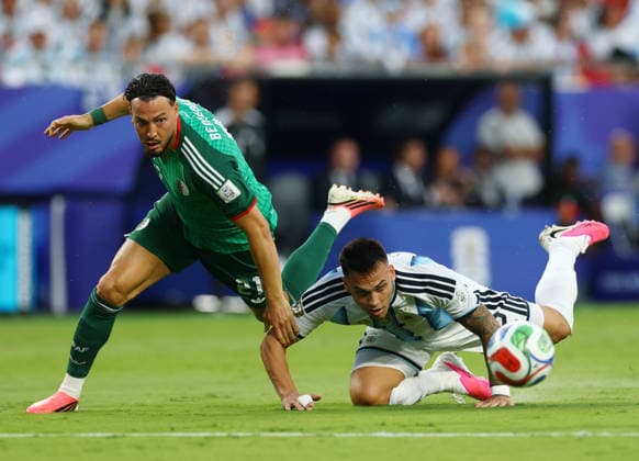 Algeria s Ramy Bensebaini (21) fights for the ball with Argentina s Lautaro Martínez in the first half in a FIFA World Cup, WM, Weltmeisterschaft, Fussball match at Arrowhead Stadium in Kansas City, Missouri, on Tuesday, June 16, 2026.  KAN20260616917 CHRISTIANxBRUNSKILL