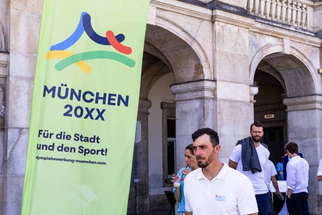 Plakat, Banner München 20XX Für die Stadt und den neben Sideris Tasiadis (Deutscher Kanuslalom-Athlet und Olympionike, Polizei, Polizist). Pressekonferenz der Spitzensportverbände vor Schloss Nymphenburg zur Vorstellung des erweiterten Münchner Bewerbungskonzepts sowie der Besonderheiten und Chancen der Landeshauptstadt als nationaler Bewerber für die Olympischen Sommerspiele