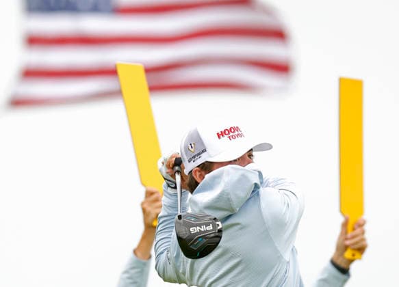 A gust of wind blows the hood from a hoodie into the face of Chase Kyes as he tees off on the 14th hole during the first round of the 126th U.S. Open Golf Championship at Shinnecock Hills Golf Club in Southampton, NY on Thursday, June 18, 2026.  NYC202606182002 JOHNxANGELILLO