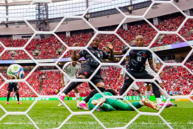 FIFA World Cup, WM, Weltmeisterschaft, Fussball 2026 - Group B - Canada vs Qatar Canada forward Cyle Larin scores past Qatar goalkeeper Mahmud Abunada as teammate Derek Cornelius looks on during the FIFA World Cup 2026 group stage match between Canada and Qatar in Vancouver, Canada, 18 June 2026. VANCOUVER Canada  Copyright: xBOBxFRIDx