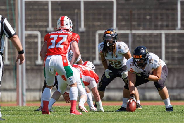 Leon Schmidt 75, Giessen Golden Dragons; in the background, Jake Höchst 22, Giessen Golden Dragons; in the foreground, Lawrence Jenkins 32, Augsburg Centurions, during the game between the Augsburg Centurions and the Giessen Golden Dragons, American football, mens, GFL2, 2026, Matchday 7 on June 20, 2026, in Augsburg, Rosenaustadion, Bavaria, Germany,detected_source_language