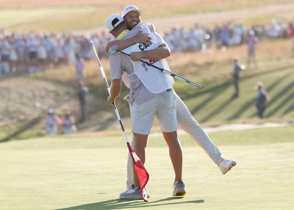 Wyndham Clark celebrates with his caddie David Pelekoudas after winning the 126th U.S. Open Golf Championship at Shinnecock Hills Golf Club in Southampton, NY, on Sunday, June 21, 2026. Clark won with a four-under-par score of 276.  NYC20260621909 JOHNxANGELILLO