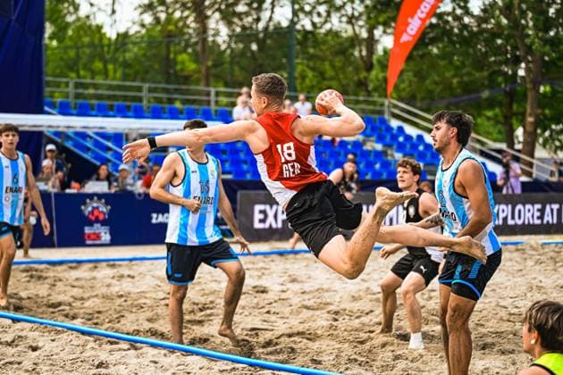 Robin John ( 18; Deutschland Beachhandball Nationalmannschaft) springt dynamisch zum Wurf und hält den Ball in der erhobenen Hand. Gegenspieler in hellblau-weißen Trikots versuchen den Abschluss zu blocken. IHF Beach Handball World Championship, WM, Weltmeisterschaft 2026, 23.06.2026, Zagreb, Jarun See *** Robin John 18, a member of the German national beach handball team, leaps dynamically to take a shot and holds the ball in his raised hand. Opponents in light blue and white jerseys attempt to block the shot. 2026 IHF Beach Handball World Championship, June 23, 2026, Zagreb, Lake Jarun,detected_source_language Copyright: xspeedshotx xDorianfrickx