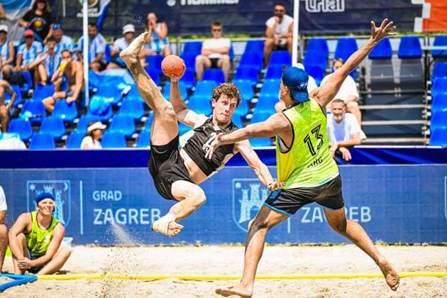 Ein Spieler der deutschen Beachhandball-Nationalmannschaft führt einen akrobatischen Sprungwurf aus, während ein argentinischer Spieler ( 13, ARG) den Block versucht. Die Szene findet am Jarun See in Zagreb vor gefüllten Zuschauerrängen statt. IHF Beach Handball World Championship, WM, Weltmeisterschaft 2026, 23.06.2026, Zagreb, Jarun See *** A player on the German national beach handball team performs an acrobatic jump shot while an Argentine player (No. 13, ARG) attempts a block. The scene takes place at Lake Jarun in Zagreb in front of packed stands during the 2026 IHF Beach Handball World Championship, June 23, 2026, Zagreb, Lake Jarun,detected_source_language Copyright: xspeedshotx xDorianfrickx