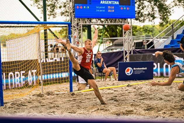 Moritz Ebert ( 26; Deutschland Beachhandball Nationalmannschaft) streckt sich in einer dynamischen Parade im Sand des Jarun Sees in Zagreb. Im Hintergrund zeigt die Anzeigetafel das Spiel gegen Argentinien. IHF Beach Handball World Championship, WM, Weltmeisterschaft 2026, 23.06.2026, Zagreb, Jarun See *** Moritz Ebert, 26, of the German national beach handball team, stretches during a dynamic save on the sand at Lake Jarun in Zagreb. In the background, the scoreboard displays the score of the match against Argentina at the 2026 IHF Beach Handball World Championship, June 23, 2026, Zagreb, Lake Jarun,detected_source_language Copyright: xspeedshotx xDorianfrickx