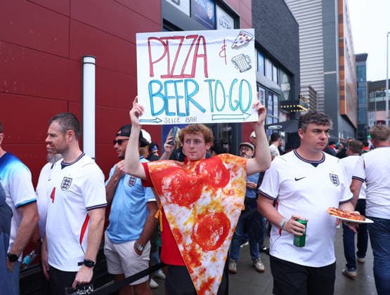 Foxborough, USA, 23rd June 2026. A pizza company employee holds up a signs promoting his take away before the England vs Ghana FIFA World Cup, WM, Weltmeisterschaft, Fussball match at Gillette Stadium, Foxborough. Picture credit should read: Paul Terry Sportimage EDITORIAL USE ONLY. No use with unauthorised audio, video, data, fixture lists, club league logos or live services. Online in-match use limited to 120 images, no video emulation. No use in betting, games or single club league player publications. SPI_008_PT_Eng_Ghana SPI-4840-0008