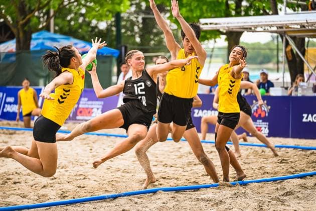 Dilayla Alarslan ( 12; Deutsche Frauen Beachhandball Nationalmannschaft) kämpft sich mit dem Ball durch drei Gegnerinnen in gelben Trikots und setzt zum Wurf an. Sand spritzt auf, während alle Beteiligten in voller Bewegung sind – Szene beim Beachhandball-Turnier am Jarun See in Zagreb. IHF Beach Handball World Championship, WM, Weltmeisterschaft 2026, 23.06.2026, Zagreb, Jarun See *** Dilayla Alarslan 12 Copyright: xspeedshotx xDorianfrickx