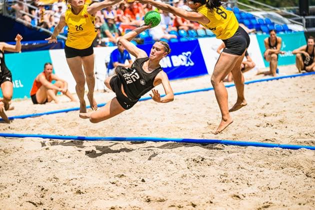 Dilayla Alarslan ( 12; Deutsche Frauen Beachhandball Nationalmannschaft) wirft in spektakulärer Flugbewegung auf das Tor, während eine Gegenspielerin den Ball abzufangen versucht. Im Hintergrund ist Spielerin 26 des gegnerischen Teams zu sehen. IHF Beach Handball World Championship, WM, Weltmeisterschaft 2026, 23.06.2026, Zagreb, Jarun See *** Dilayla Alarslan, a member of the German womens beach handball national team, shoots at the goal in a spectacular leap, while an opponent tries to intercept the ball. Player No. 26 from the opposing team can be seen in the background. 2026 IHF Beach Handball World Championship, June 23, 2026, Zagreb, Lake Jarun,detected_source_language Copyright: xspeedshotx xDorianfrickx