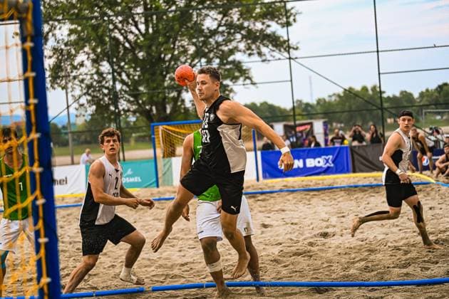 Robin John ( 18; Deutsche Beachhandball Nationalmannschaft) holt zum Wurf aus und hält den Ball über dem Kopf bereit. Im Sand des Beachhandball-Courts am Jarun See in Zagreb sind mehrere Gegenspieler in grün-weißen Trikots in der Szene. IHF Beach Handball World Championship, WM, Weltmeisterschaft 2026, 23.06.2026, Zagreb, Jarun See *** Robin John 18 Copyright: xspeedshotx xDorianfrickx