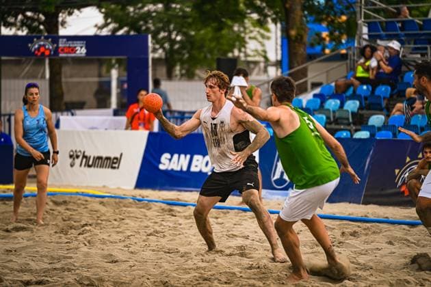 HENRICH Severin ( 13; Deutschland Beachhandball Nationalmannschaft) hält den Ball und sucht eine Anspielstation, während ein Gegenspieler im grünen Trikot ihn unter Druck setzt. Im Hintergrund ist eine Schiedsrichterin sowie die Werbebande mit Hummel-Logo am Jarun See in Zagreb zu sehen. IHF Beach Handball World Championship, WM, Weltmeisterschaft 2026, 23.06.2026, Zagreb, Jarun See *** HENRICH Severin, No. 13 on the German national beach handball team, holds the ball and looks for a teammate to pass to, while an opponent in a green jersey puts pressure on him. In the background, a female referee and the advertising banner featuring the Hummel logo can be seen at Lake Jarun in Zagreb. IHF Beach Handball World Championship 2026, June 23, 2026, Zagreb, Lake Jarun,detected_source_language Copyright: xspeedshotx xDorianfrickx
