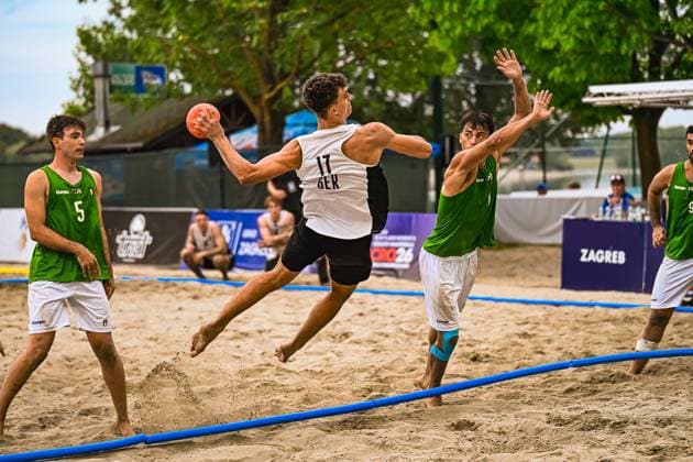KRAUTH Tim ( 17; Deutschland Beachhandball Nationalmannschaft) springt dynamisch über die Seitenlinie und zieht zum Wurf ab, während ein italienischer Abwehrspieler den Arm hochreißt. Die Szene findet am Jarun See in Zagreb statt. IHF Beach Handball World Championship, WM, Weltmeisterschaft 2026, 23.06.2026, Zagreb, Jarun See *** KRAUTH, Tim, 17, of the German national beach handball team, leaps dynamically over the sideline and takes a shot, while an Italian defender raises his arm. The scene takes place at Lake Jarun in Zagreb during the 2026 IHF Beach Handball World Championship, June 23, 2026, Zagreb, Lake Jarun,detected_source_language Copyright: xspeedshotx xDorianfrickx