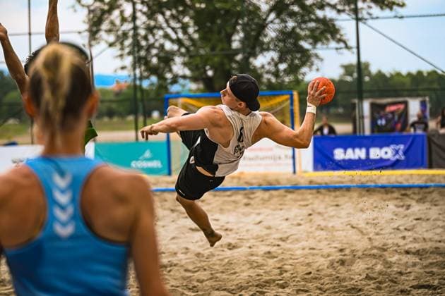 Ein Spieler der deutschen Beachhandball-Nationalmannschaft springt mit dem Ball in der Wurfhand dynamisch über den Sand und zielt aufs Tor. Im Vordergrund ist ein Gegenspieler in blauem Trikot unscharf zu sehen. IHF Beach Handball World Championship, WM, Weltmeisterschaft 2026, 23.06.2026, Zagreb, Jarun See *** A player on the German national beach handball team dynamically leaps across the sand with the ball in his shooting hand, aiming for the goal. In the foreground, an opponent in a blue jersey is visible out of focus. IHF Beach Handball World Championship 2026, June 23, 2026, Zagreb, Lake Jarun,detected_source_language Copyright: xspeedshotx xDorianfrickx