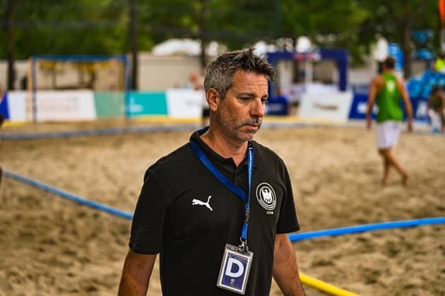 Ein Offizieller der deutschen Beachhandball-Nationalmannschaft steht konzentriert am Spielfeldrand beim Turnier am Jarun See in Zagreb. Im Hintergrund ist das Spielfeld mit weiteren Akteuren zu sehen. IHF Beach Handball World Championship, WM, Weltmeisterschaft 2026, 23.06.2026, Zagreb, Jarun See *** An official from the German national beach handball team stands intently on the sidelines during the tournament at Lake Jarun in Zagreb. In the background, the playing field can be seen with other players. IHF Beach Handball World Championship 2026, June 23, 2026, Zagreb, Lake Jarun,detected_source_language Copyright: xspeedshotx xDorianfrickx