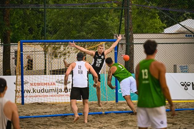 Moritz Ebert ( 26; Deutschland Beachhandball Nationalmannschaft) streckt beide Arme aus und verteidigt das Tor gegen einen Wurf des Gegners im Sand. Tobias Zeyen ( 12; Deutschland) steht als Feldspieler vor ihm, während zwei Gegner in grünen Trikots den Abschluss suchen. IHF Beach Handball World Championship, WM, Weltmeisterschaft 2026, 23.06.2026, Zagreb, Jarun See *** Moritz Ebert, No. 26, of the German national beach handball team, stretches out both arms to defend the goal against an opponent’s shot in the sand. Tobias Zeyen, No. 12, of Germany, stands in front of him as a field player, while two opponents in green jerseys look to score. 2026 IHF Beach Handball World Championship, June 23, 2026, Zagreb, Lake Jarun,detected_source_language Copyright: xspeedshotx xDorianfrickx