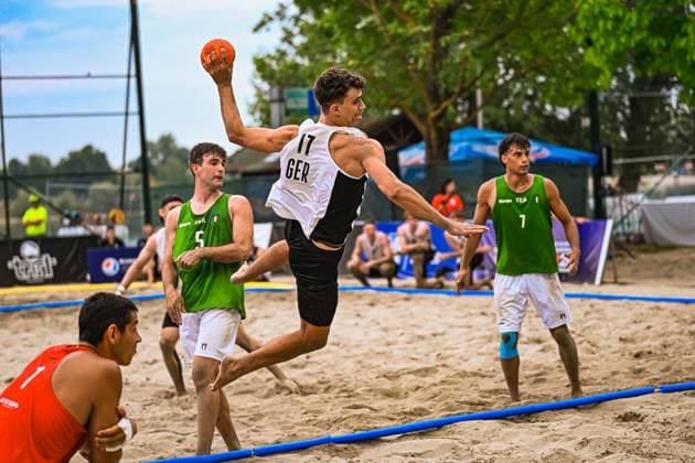 Tim Krauth ( 17; Deutschland Beachhandball Nationalmannschaft) springt hoch und zieht zum Wurf ab, während Spieler Italiens die Abwehr organisieren. Der Torwart Italiens lauert in der Ecke auf den Abschluss. IHF Beach Handball World Championship, WM, Weltmeisterschaft 2026, 23.06.2026, Zagreb, Jarun See *** Tim Krauth, 17, of the German national beach handball team, jumps high and takes a shot while Italian players organize their defense. The Italian goalkeeper lies in wait in the corner for the shot. 2026 IHF Beach Handball World Championship, June 23, 2026, Zagreb, Lake Jarun,detected_source_language Copyright: xspeedshotx xDorianfrickx