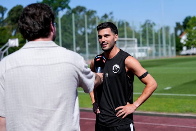 Mert Tasdelen (SVS, 11), mit Mikrofon beim Interview zum Saisonauftakt vor dem Training, TV, Fernsehen, Einzelbild, Einzelfoto, Aktion, Action, 24.06.2026, Sandhausen (Deutschland), Fussball, Regionalliga Südwest, Trainingsauftakt beim SV Sandhausen *** Mert Tasdelen (SVS), 11, holding a microphone during an interview at the start of the season before practice; TV, television, still image, single photo, action, June 24, 2026, Sandhausen, Germany; soccer, Regionalliga Südwest; start of training at SV Sandhausen,detected_source_language xozx