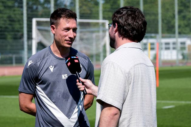 Kevin Stotz (Trainer, Cheftrainer, SVS), mit Mikrofon beim Interview zum Saisonauftakt vor dem Training, TV, Fernsehen, Einzelbild, Einzelfoto, Aktion, Action, 24.06.2026, Sandhausen (Deutschland), Fussball, Regionalliga Südwest, Trainingsauftakt beim SV Sandhausen *** Kevin Stotz, Coach, Head Coach, SVS, holding a microphone during an interview at the start of the season before practice; TV, television, still image, single photo, action, June 24, 2026, Sandhausen, Germany; soccer, Regionalliga Südwest, start of training at SV Sandhausen,detected_source_language xozx