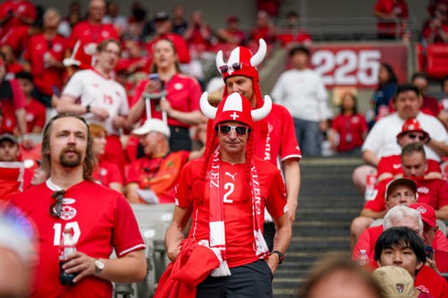 Kanada: Fußball FIFA Weltmeisterschaft 2026 Gruppenphase Schweiz vs Kanada BC Place Stadium (Vancouver, British Columbia): Schweizer Fußballfans auf der Tribüne, Zuschauer, Fanblock, Fankultur, Schweiz-Fahnen, Nationalflagge, Fanperücke in Rot-Weiß, Fanbekleidung, Fanporträt, Unterstützung der Schweizer Nationalmannschaft, Stadionatmosphäre, Emotionen, Spannung, Länderspiel, Fußballbegeisterung, Public-Viewing-Stimmung, rot-weiße Farben, Supporter, Tribüne, Sportevent, Schweiz-Anhänger, Fahnen, Teamgeist, Nahaufnahme, Impression. *** Canada Soccer 2026 FIFA World Cup Group Stage Switzerland vs. Canada BC Place Stadium Vancouver, British Columbia Swiss soccer fans in the stands, spectators, fan section, fan culture, Swiss flags, national flag, red-and-white fan wig, fan apparel, fan portrait, support for the Swiss national team, stadium atmosphere, emotions, excitement, international match, soccer enthusiasm, public viewing atmosphere, red and white colors, supporters, stands, sporting event, Swiss supporters, flags, team spirit, close-up, impression Copyright: xJOERANxSTEINSIEKx