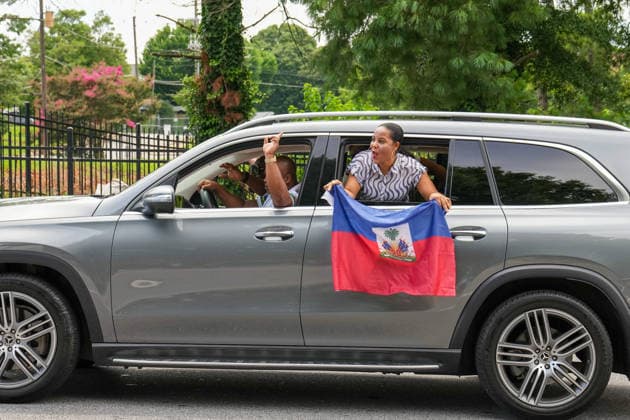 June 24, 2026, Atlanta, Georgia, United States of America: A Haiti fan leans out the window waving a Haiti flag during the Haiti fan march before the Morocco vs Haiti First Stage Group C match in ATLANTA, Georgia. Atlanta United States of America - ZUMAg276 20260624_zsp_g276_011 Copyright: xMalachixGabrielx