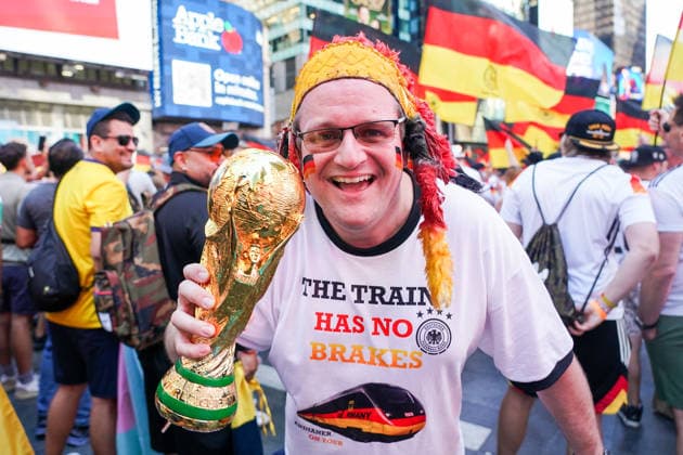 Fans aus Deutschland und Ecuador feiern friedlich zusammen vor dem Gruppenspiel auf dem Times Square, Deutscher Fan erinnert daran, dass der Zug zum Titel keine Bremsen hat - New York 24.06.2026: Times Square Fan Aufmarsch vor Deutschland gegen Ecuador *** Fans from Germany and Ecuador celebrate peacefully together in Times Square ahead of the group stage match; a German fan reminds everyone that the team’s run toward the title is unstoppable. New York, June 24, 2026: Fan gathering in Times Square ahead of Germany vs. Ecuador