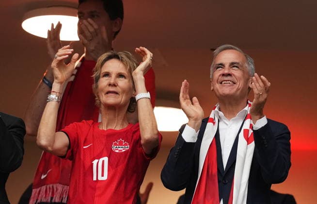June 24, 2026, Vancouver, Bc, CANADA: Prime Minister Mark Carney cheers with his wife Diana Fox Carney as players enter the field prior to the first half of a World Cup Group B soccer match between Canada and Switzerland, in Vancouver, on Wednesday, June 24, 2026. Canada News - June 24, 2026  - ZUMAc35_ 20260624_zaf_c35_096 Copyright: xEthanxCairnsx