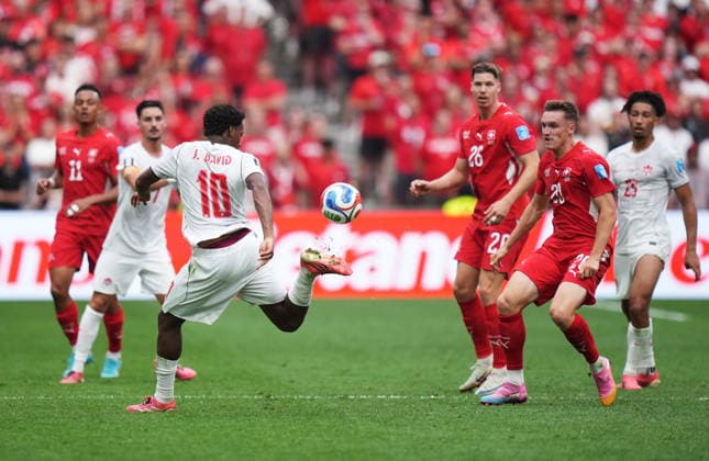 June 24, 2026, Vancouver, Bc, CANADA: Canada s Jonathan David (10) plays the ball as Switzerland s Michel Aebischer (20) looks on during the second half of a World Cup Group B soccer match, in Vancouver, on Wednesday, June 24, 2026. Canada News - June 24, 2026  - ZUMAc35_ 20260624_zaf_c35_244 Copyright: xDarrylxDyckx