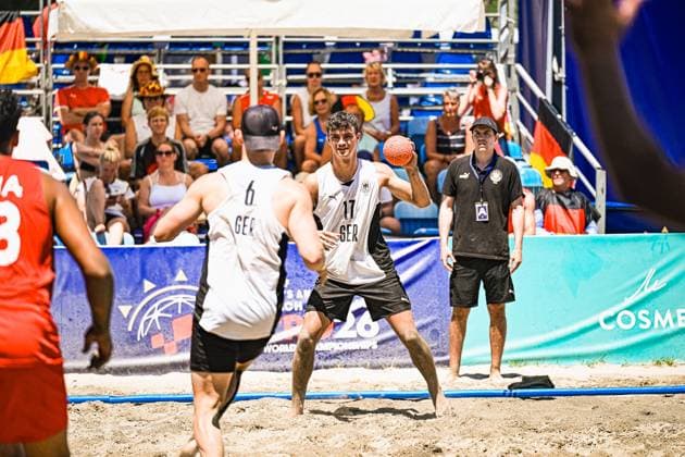 Tim Krauth ( 17; Deutschland Beachhandball Nationalmannschaft) hält den Ball in der Wurfvorbereitung und sucht die Anspielstation, während Lars Zelser ( 6; Deutschland Beachhandball Nationalmannschaft) als Anspielpartner bereitsteht. Im Hintergrund verfolgen zahlreiche Zuschauer mit deutschen Fahnen das Spiel am Jarun See in Zagreb. IHF Beach Handball World Championship, WM, Weltmeisterschaft 2026, 23.06.2026, Zagreb, Jarun See *** Tim Krauth, No. 17 on the German national beach handball team, holds the ball as he prepares to shoot and looks for a teammate to pass to, while Lars Zelser (No. 6) of the German national beach handball team stands ready as the receiving player. In the background, numerous spectators waving German flags watch the game at Lake Jarun in Zagreb. IHF Beach Handball World Championship 2026, June 23, 2026, Zagreb, Lake Jarun Copyright: xspeedshotx xDorianfrickx